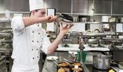Ein Koch bei der Speisezubereitung in einer Hotelküche. (Bild: Christian Beutler/Keystone (Zürich, 30. März 2017))