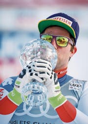 Am Ziel angekommen: Beat Feuz küsst seine erste Kristallkugel. (Bild: EPA (Are, 14. März 2018))