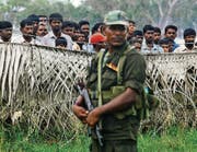 Warten auf die Heimkehr: Tamilen, bewacht von der Armee, in einem Lager bei der Stadt Vavuniya. (Bild: ap/Eranga Jayawardena)
