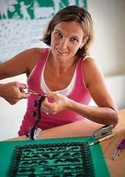 Kunsthandwerk mit Miniatur-Charakter: Jolanda Brändle arbeitet an einem Scherenschnitt, rechts das fertige Olma-Plakat. (Bilder: Ralph Ribi/olma)