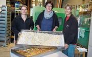 Vor dem grünen Ofen: Isabelle Baumberger, Claudia Gemperli und Gabi Graf sind die Herrinnen des Dörrbetriebs. (Bild: Maya Heizmann)