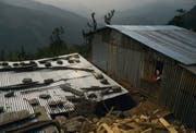 Die Wellblechdächer vieler Notunterkünfte von Erdbebenopfer an den steilen Berghängen im Kathmandutal glitzern in der nepalesischen Mittagssonne. (Bild: Benjamin Manser (SRK / Benjamin Manser))