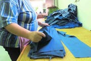Hosen zusammenlegen: Die Sozialfirmen bieten einfache Arbeiten. (Archivbild: Susann Basler)