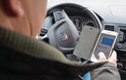 So nicht: Wer Auto fährt, soll sich auf den Verkehr konzentrieren. Ablenkung ist eine der häufigsten Unfallursachen. (Bild: Stephanie Sonderegger)