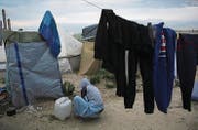 Ein afrikanischer Flüchtling wäscht im «Dschungel» von Calais seine Habseligkeiten. (Bild: Thibault Camus/AP, 15. Oktober 2016)