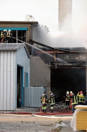 Feuerwehrleute bekämpfen den Brand in der Metallverarbeitungsfirma. (Bild: Stefan Hilzinger (20. März 2014))