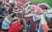 Aufwärmen gehört zum Sport: Diese Lektion erteilt Weltstar Sally Pearson (Mitte) den Kindern und Jugendlichen in Frauenfeld und geht mit gutem Beispiel voran. (Bild: Reto Martin)