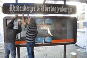 Korrektor Ernst Hobi und Reinigungskraft Werner Graf montieren den Schaukasten ab. (Bild: Ursula Wegstein)