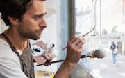 Mathias Truniger bei der Arbeit mit der Neubeschriftung der Kaffeerösterei Baumgartner in der St. Galler Altstadt. (Bild: Joa Schmid, Büro Sequenz)