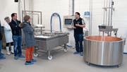 Fachplaner Jann Walder (ganz rechts) erklärt die technische Einrichtung der neuen Schulkäserei. (Bilder: Katharina Rutz)