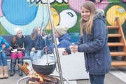 Kira von der Jugendarbeit Müllheim kocht Tee am offenen Feuer: Im Hintergrund das bunte «Rolling House». (Bild: Marlies Kunz)
