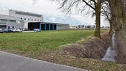 Auf dieser grünen Wiese an der Scharastrasse in Haag, zwischen der Druckerei und dem kleinen Bach, möchte die Politische Gemeinde Sennwald eine Parkanlage mit 94 Abstellplätzen errichten. (Bild: Heini Schwendener)