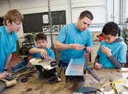 Ein Raketenauto entsteht: Instruktor Roger Eichenberger unterstützt die Workshop-Teilnehmer bei ihrem Projekt. (Bild: Hugo Berger)