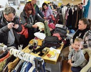 Der junge Verkäufer hat Spass, während interessierte Besucher stöbern. (Bilder: Christoph Heer)