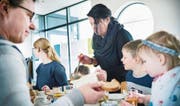 Besucher geniessen die Mais-Rüebli-Erbsensuppe in geselliger Runde am grossen Tisch. (Bild: Andrea Stalder)