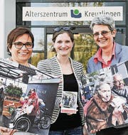 Ursi Rieder (links) und Anna Jäger (rechts) vom Alterszentrum zeigen mit Anina Flury von «Radeln ohne Alter» einige Impressionen von solchen Events an anderen Orten. (Bild: Donato Caspari)