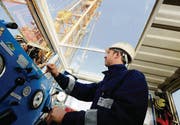 Driller Alexander Sesler in seiner Kabine: Hier überwacht und steuert er die Bohrung. Der Bohrturm ragt im Hintergrund auf. (Bilder: Donato Caspari)