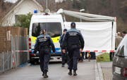 Polizisten an jener Strasse in Rupperswil, wo sich die Bluttat ereignete. (Bild: PATRICK B. KRAEMER (KEYSTONE))