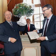 Ehrenbürger Angelus Hux erhält von Bürgerpräsident Titus Moser Blumen und Urkunde; im Hintergrund Thomas Pallmann, der die Laudatio hielt. (Bild: Nana do Carmo)