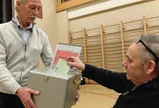 Stimmenzähler Herbert Mazur sammelt mit der Urne die Zettel ein. (Bild: Stefan Hilzinger)