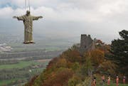 Die elf Meter hohe Replik der Statue des Cristo Redentor von Rio de Janeiro fliegt per Kamov-Helikopter zum neuen Standort nahe der Ruine Wartenstein in Pfäfers. (Bild: Keystone/Gian Ehrenzeller)