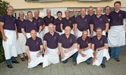 Die Walzehuser Hobbyköch beschenkten sich zum Zwanzigjährigen mit einem neuen Poloshirt. Dieter Geuter (vordere Reihe, links) leitet die Kochabende seit der Gründung. (Bild: Isabelle Kürsteiner)