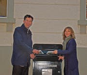 Robin Alder, Präsident der Arbeitgebervereinigung, und Paula Looser, Bibliotheksleiterin, beim neuen Medienrückgabekasten. (Bild: PD)