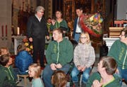 Mirta Ammann, bekannt als Clown Mili, umrahmt von Stiftungsratspräsident Ivo Bischofberger, Ratschreiber Markus Dörig sowie vielen Kindern und Jugendlichen der Musikgruppe «Erscht Rächt». Im Hintergrund Pfarrer Lukas Hidber. (Bild: Roger Fuchs)