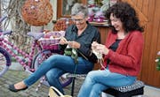 Nicole Fischer und Margrit Tanner bereiten Strickwaren vor; Teilnehmer des Erlebnistages können daran weiterarbeiten. (Bild: Monika Wick)