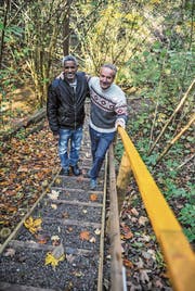 Solomon Tesfalen und Peter Brunner posieren auf einer der Treppen, die sie auf dem Wanderweg durch das Wängemer Hexentobel gebaut haben. (Bild: Olaf Kühne)