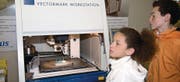 Diese beiden jungen Besucher inspizieren aufmerksam eine Laserbeschriftungsmaschine. (Bild: Andreas Taverner)