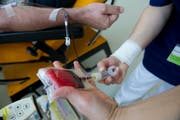 Lebenswichtiger «Rohstoff»: Eine Mitarbeiterin des Blutspendedienstes nimmt einem Spender das Blut ab. (Bild: Ralph Ribi)