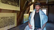 Alex Brotbeck in der Ausstellung. Als Umhang trägt er eines der Bilder auf Baustellenvlies. (Bild: Mario Testa)