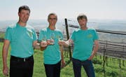 Ein Müller-Thurgau im Glas, die Iselisberger Rebberge sowie die Aussicht auf das Thurtal im Rücken: Stefan Keller, Thomas Frei und Günter Hartmann als Präsident bilden den Vorstand des neuen Winzervereins. (Bild: Mathias Frei)
