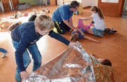 Im Nothilfekurs mit Globi lernen die Kinder von Sabina Pipping, wie man Bewusstlose seitlich lagert und warmhält. (Bild: Hanspeter Thurnherr)