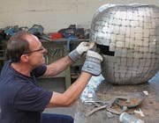 Der Zuzwiler Apfel gedeiht: Künstler Alf Suter bei der Gestaltung der künstlichen Frucht aus circa 700 verschieden grossen Blechteilchen.