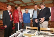 Der Ausserrhoder Landammann Matthias Weishaupt, Oliver und Bea Wackernagel und der Innerrhoder Landammann Roland Inauen lassen sich von Fotograf Mäddel Fuchs die Bildersammlung erklären. (Bild: mge)