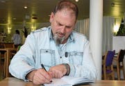 René Hengartner signiert in der Rehaklinik Zihlschlacht seine Geschichte im Buch «Sieben Leben». (Bild: Yvonne Aldrovandi-Schläpfer)
