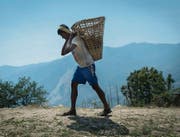 Ein Nepalese schleppt Steine als Baumaterial über steile Hänge des Kathmandutals. (Bild: Benjamin Manser (SRK / Benjamin Manser))