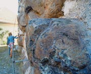 Ein Brocken Kissenlava am Schlossturm. Im Hintergrund begutachten Mineralogin Christine Bläuer und Museumsdirektorin Gabriele Keck andere Findlinge. (Bild: Mathias Frei)