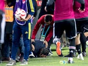 Besiktas-Coach Senol Günes krümmt sich nach dem Messerwurf vor Schmerz auf dem Rasen (Bild: KEYSTONE/EPA/SEDAT SUNA)
