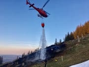 Löschen mit Wasser aus dem Gantrischsee: Ein Helikopter bekämpft den Waldbrand in Blumenstein. (Bild: Kapo BE)