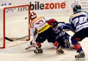Mathieu Tschantré vom EHC Biel schiesst ein Tor gegen Goalie Lars Weibel und Patrick Oppliger vom EV Zug. (Bild Keystone)