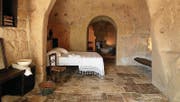 Das Bett steht in der Grotte: Höhlenzimmer aus Tuffstein in Matera. (Bild: PD)