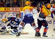 EVZ-Goalie Lars Weibel, Ryan Gardner von den ZSC Lions und Josh Holden im Kampf um den Puck.(Bild Keystone)