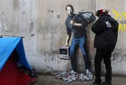 Das neuste Werk von Banksy am Eingang des Flüchtlingscamp in Calais. (Bild: AP Photo/ Michel Spingler)