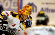 Patrick Thoresen vom HC Lugano, vorne, und Patrick Fischer vom EV Zug beobachten den Puck. (Bild Keystone)