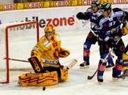 Goalie Matthias Schoder von den Tigers wehrt den Puck von Duri Camichel (Mitte) und Lee Goren vom EV Zug ab. (Bild Keystone)
