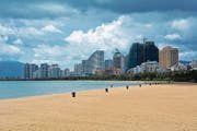 Der palmengesäumte Strand von Sanya ist tagsüber menschenleer. Moderne Appartmenttürme dominieren das nördliche Stadtzentrum. (Bild: Andreas Fässler)
