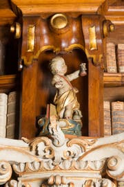 Der Arzt mit den Attributen Uringlas, Medizinflasche und Büchern. Putte im Barocksaal der Stiftsbibliothek St.Gallen um 1770. (Bild: Stiftsbibliothek St.Gallen)